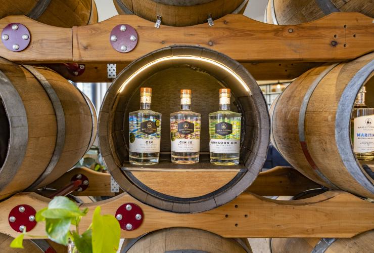 Three different types of gin on display in a round oak barrel at Bass & Flinders Distillery, Mornington Peninsula, Victoria © Tourism Australia