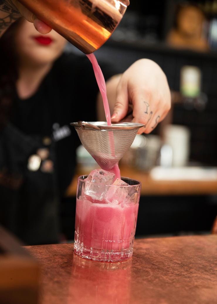 Bartender pouring a bright pink cocktail at the Four Pillars Gin Distillery, Yarra Valley, Victoria © Visit Victoria