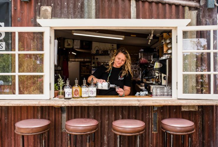 Bartender pouring a shot inside a barstool-lined window at Kangaroo Island Spirits, Kangaroo Island, South Australia © Meaghan Coles