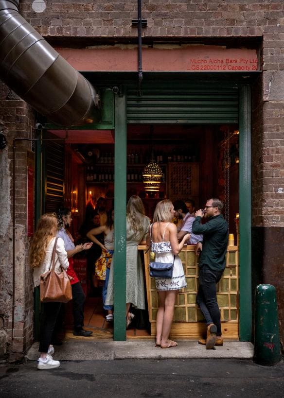 A group of people gathered inside a small bar drinking cocktails at Cantina OK!, Sydney CBD, New South Wales © Destination NSW
