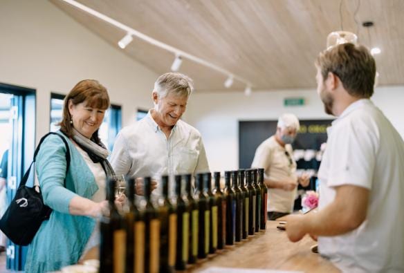 Couple browsing varieties of olive oil at Olio Bello, Margaret River, Western Australia © Tourism Australia 