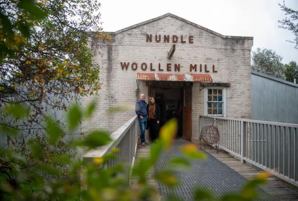 Couple standing in front of the heritage facade of the Nundle Woolen Mill, New England, New South Wales © Tourism Australia