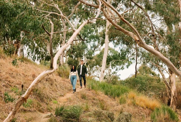 Couple walking down a hill in the bush at Wilga Station, Bathurst, New South Wales © Tourism Australia