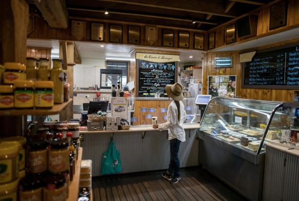 A visitor explores a dairy farm gift shop with farm-themed giftware, local jams, honey and cheeses at Bega Cheese Heritage Centre, South Coast, New South Wales © Tourism Australia