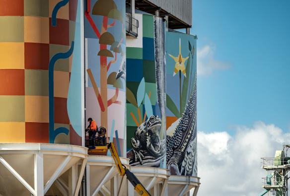 A person on a forklift painting a series of colourful murals on silos along the PUBLIC Silo Trail, Newdegate, Western Australia © Bewley Shaylor