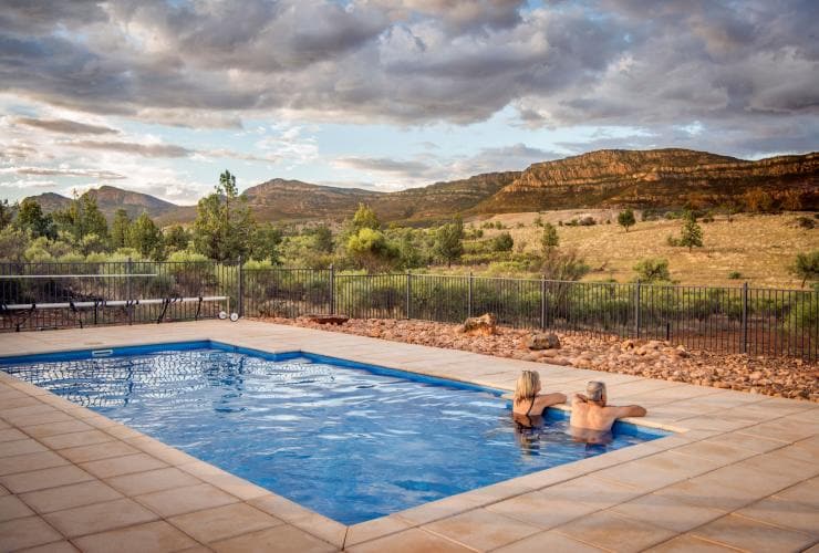 A couple lounging in the private pool of Rawnsley Park Station homestead while overlooking the Flinders Ranges, South Australia © Rawnsley Park Station