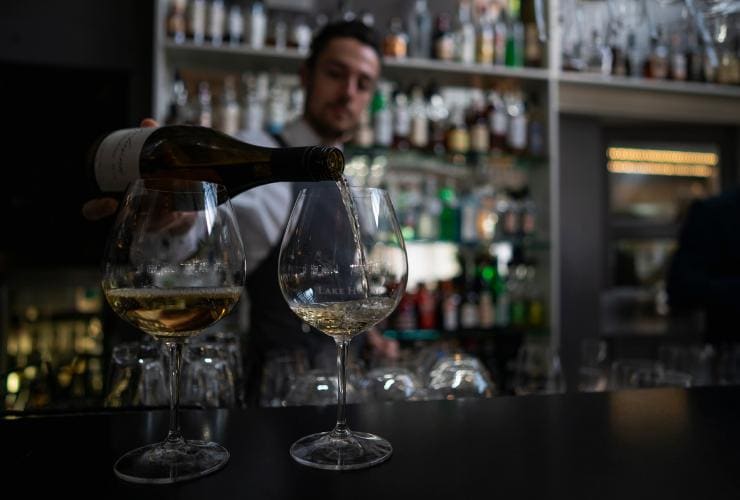 A bartender pouring wine, Lake House, Daylesford, Victoria © Tourism Australia