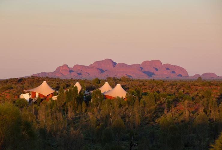 Luxury tented pavilions tucked within bushland with red rock formations in the distance, Longitude 131, Uluru-Kata Tjuta, Northern Territory © Longitude 131