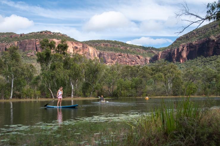 Family kayaking and stand-up paddle boarding beside bushland-covered mountains, Mt Mulligan Lodge, Mount Mulligan, Queensland © Tourism and Events Queensland