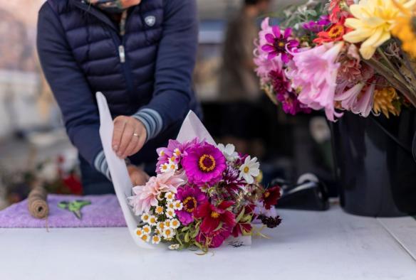 Woman wrapping flowers at Harvest Market, Launceston, Tasmania © Tourism Australia