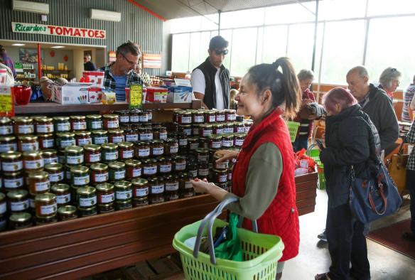 The busy farm shop at Ricardoes Tomatoes & Strawberries has many customers walking through looking at the homemade rows of jams, preserves and fresh produce, Barrington Coast, New South Wales © Tourism Australia