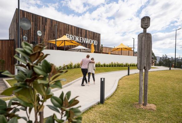 A couple walking along the entrance path into ​Brokenwood Wines, Pokolbin, New South Wales © Tourism Australia​