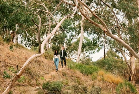 Couple walking down a hill in the bush at Wilga Station, Bathurst, New South Wales © Tourism Australia