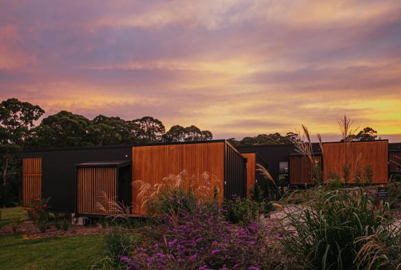 Luxury lodges against a purple sunset at Cupitt’s Estate, South Coast, New South Wales © Tourism Australia