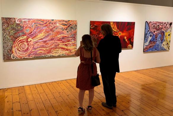 A couple looks at a wall of Indigenous art pieces at Japingka Gallery, Fremantle, Western Australia © Japingka Gallery