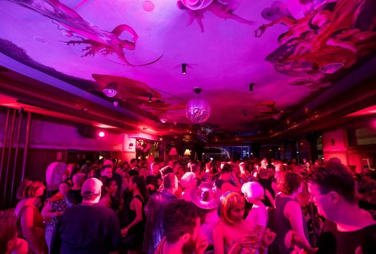 A crowd of people dancing in a pink light-filled hotel, The Imperial Hotel, Sydney, New South Wales © Destination NSW