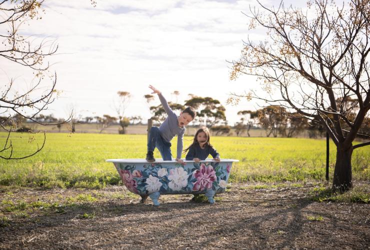 Two children playing in an outdoor tub, Redwing Farm, Yorke Peninsula, South Australia © Tourism Australia