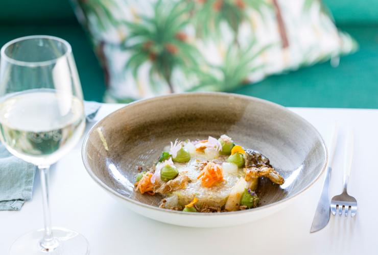 A colourful dish beside a glass of white wine, Snapper Rocks, Darwin, Northern Territory © Tourism NT