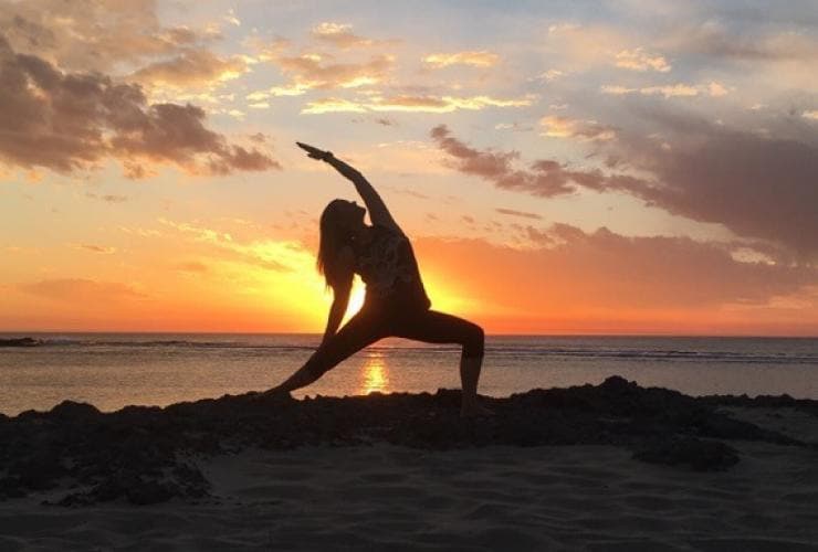 A person doing a yoga pose overlooking views of the ocean during sunset at Injidup Spa Retreat, Yallingup, Margaret River Region, Western Australia © Devahiti Yoga & Bodywork