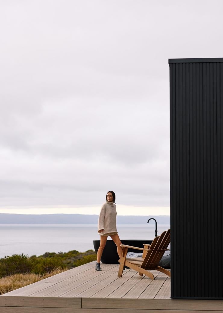 A person walking across a balcony with a tub overlooking a coastline, Cabn, Kangaroo Island, South Australia © South Australian Tourism Commission