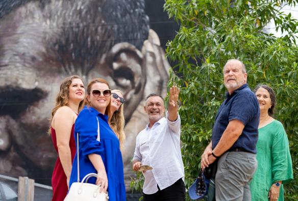Tour group paused in a circle listening to the tour guide, Darwin Gourmet Tour, Darwin, Northern Territory © Tourism Australia