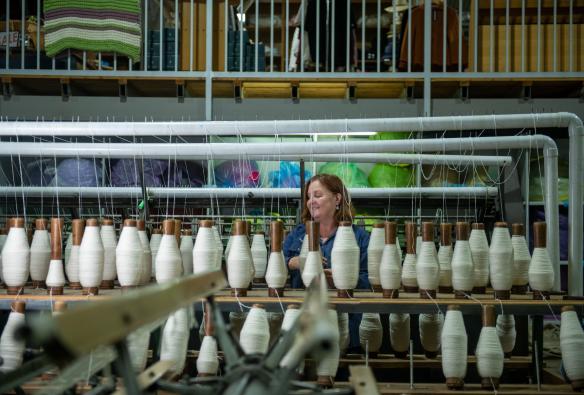 Woman spins strings of wool at the Nundle Woolen Mill, New England, New South Wales © Tourism Australia