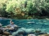 Woman sits on rock beside rockpool at Mossman Gorge © Tourism and Events Queensland