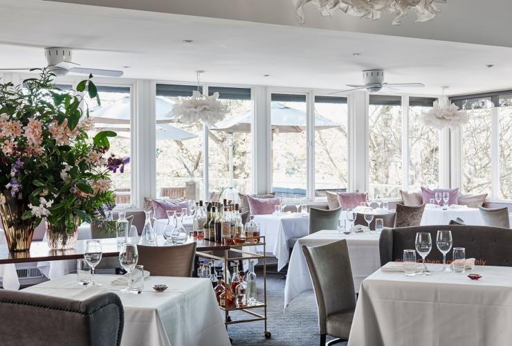 A light-filled restaurant with flowers, chandeliers and a drinks trolley, Lake House, Daylesford Restaurant, Victoria © Lisa Cohen