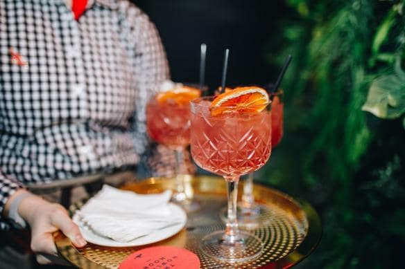 A server carrying a tray of bright orange cocktails at Howling Moon, Canberra, Australian Capital Territory © VisitCanberra