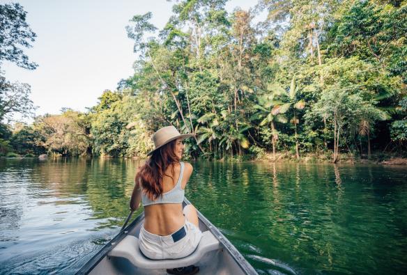 Woman paddling a canoe on Mossman Gorge River while surrounded by the Daintree Rainforest near Silky Oaks Lodge, Queensland © Tourism and Events Queensland