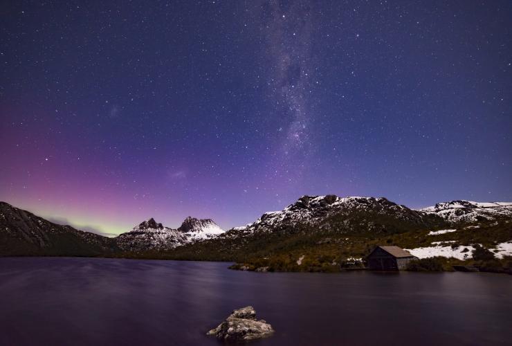 The Aurora Australis lighting up the star filled sky in hues of pink, blue and green over Cradle Mountain, Tasmania © Pierre Destribats