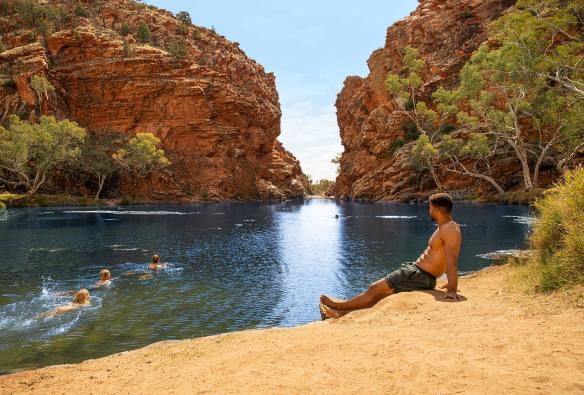 A man sits on the sand near Ellery Creek Big Hole, West MacDonnell Ranges, Northern Territory © Tourism Australia