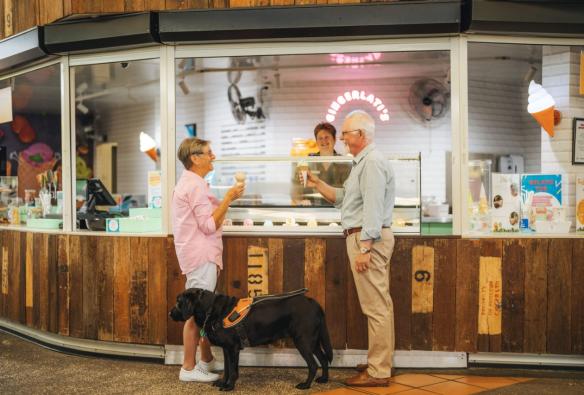 Couple accompanied by a service dog enjoying ginger treats at the Ginger Factory, Sunshine Coast, Queensland © Tourism and Events Queensland