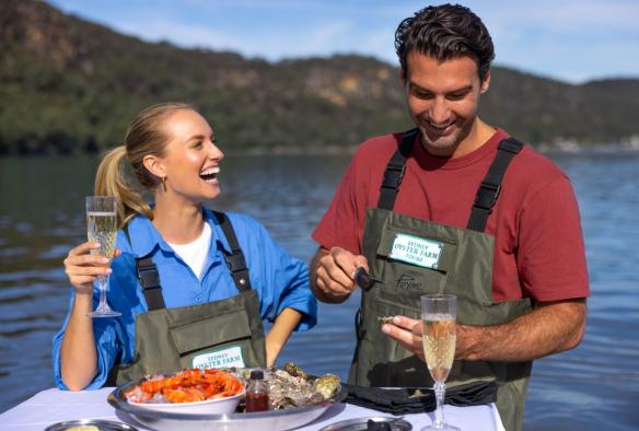 Couple enjoying oysters and sparkling wine at Sydney Oyster Farm Tours, Mooney Mooney, New South Wales © Tourism Australia