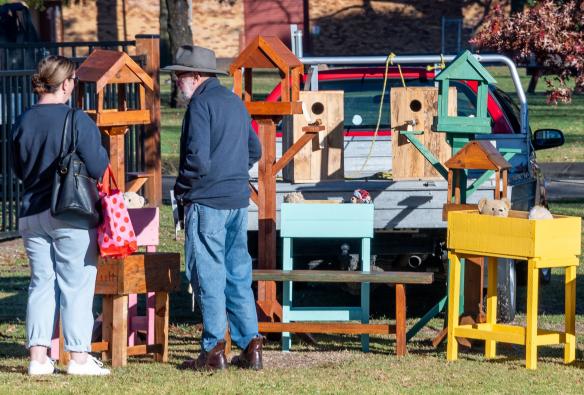 Locals admire handmade wooden bird houses at the Armidale Farmers Market, Armidale New South Wales © LightCatcher Images
