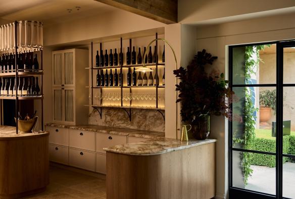Interior of a restaurant with rows of wine bottles and greenery visible through a window at LVN, Bird in Hand, Adelaide Hills, South Australia © Bird in Hand