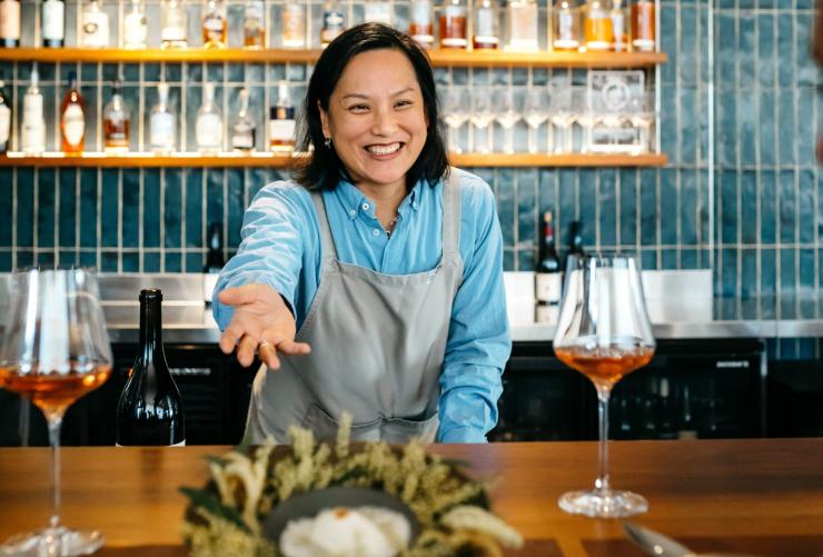 A restaurant staff member  presenting a dish over a counter, Pipit, Pottsville, New South Wales © Destination NSW 