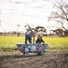 A young boy and girl play in an outdoor bathtub painted with flowers at Redwing Farm, Yorke Peninsula, South Australia © Tourism Australia 
