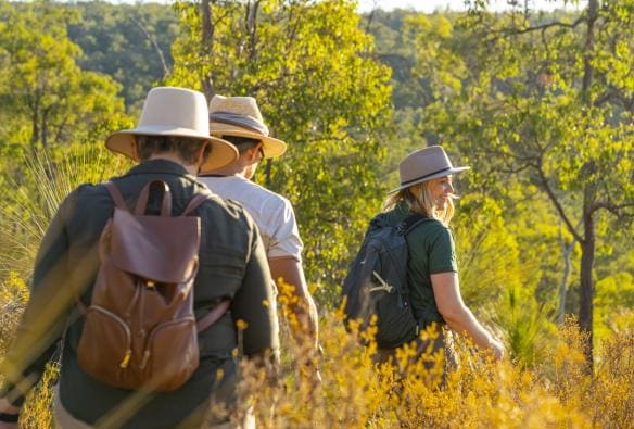 A tour guide leading guests on a hike through bright green bushland, The Hike Collective, Perth, Western Australia © Tourism Australia