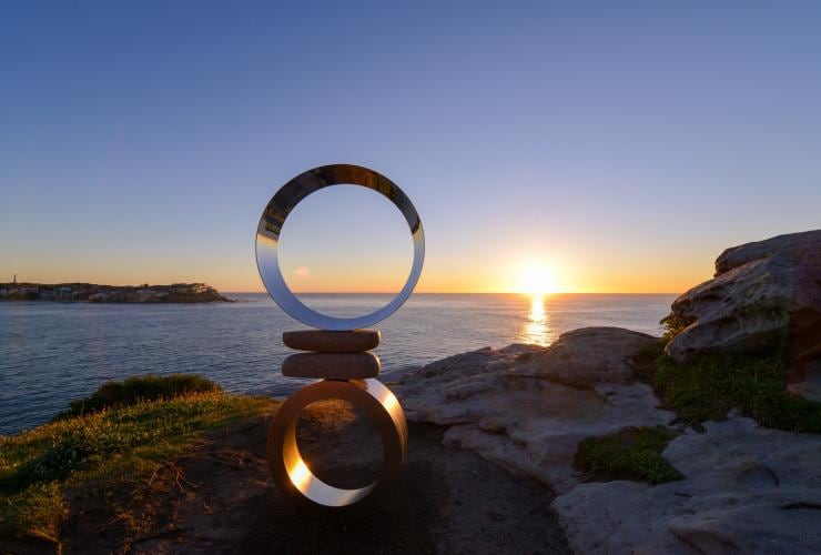 Une sculpture composée de formes métalliques au bord de l'océan au lever du soleil, Mountains Air par Koichi Ishino, Sculpture by the Sea, Bondi, Nouvelle-Galles du Sud © Clyde Yee 