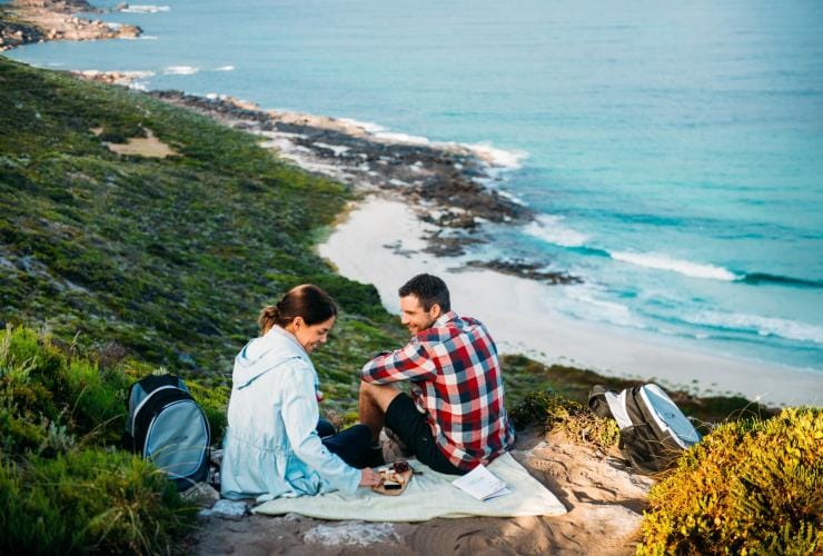 Rencontrez des clients profitant d'un déjeuner gastronomique sur le sentier de randonnée Cape to Cape au-dessus de Conto Spring Beach, WA © Tourism Western Australia et Walk Into Luxury 