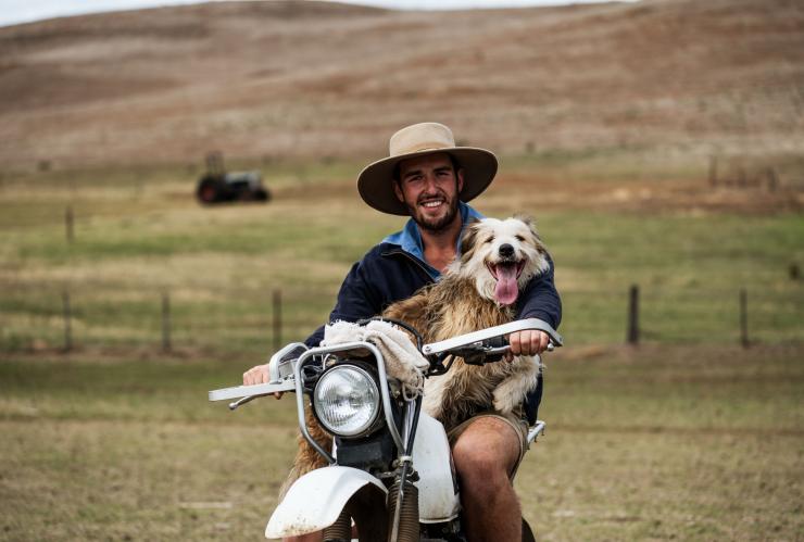 Un agriculteur et son chien assis sur une moto à Curringa Farm, Hamilton, Tasmanie © Stu Gibson 