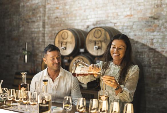 Un homme et une femme versant du rhum dans des verres à la Bundaberg Rum Distillery, Bundaberg, Queensland © Tourism and Events Queensland