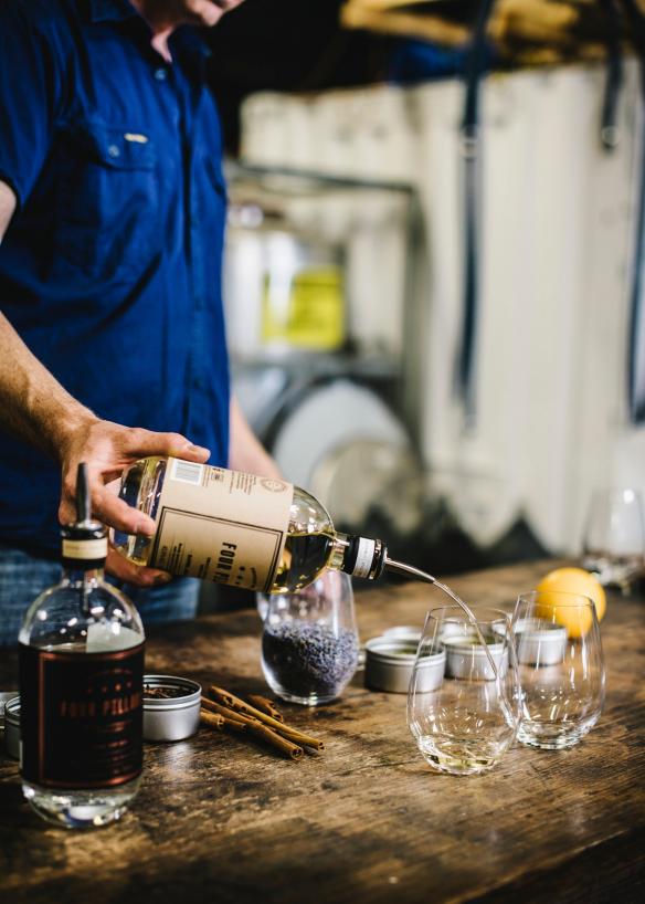 Un guide touristique servant du gin dans un verre pour une dégustation à la Four Pillars Gin Distillery, Yarra Valley, Victoria © Tourism Australia