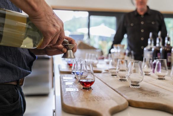 Gros plan d'un barman préparant des planches de dégustation de spiritueux à la McHenry Distillery, Tasman Peninsula, Tasmanie © Tourism Australia