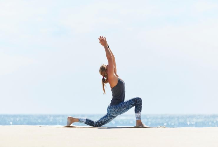 Femme exécutant une posture de yoga sur la plage au Injidup Spa Retreat à Margaret River, WA © Injidup Spa Retreat