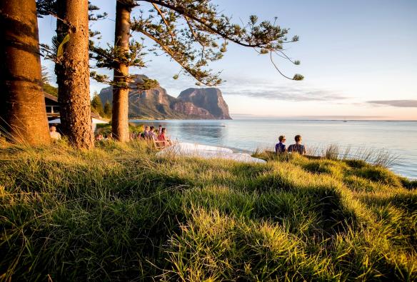 Un groupe de personnes réuni à l'extérieur du Pinetrees Lodge, au bord de l'océan, Great Walks of Australia, Seven Peaks Walk, Lord Howe Island, Nouvelle-Galles du Sud © Great Walks of Australia/Luke Hanson