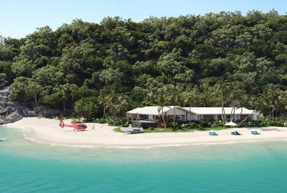 Vue aérienne d'un bâtiment situé près d'une forêt tropicale sur un littoral de sable blanc, près duquel se trouve un hélicoptère rouge, à Pelorus Private Island, Palm Island, Queensland © Pelorus Private Island