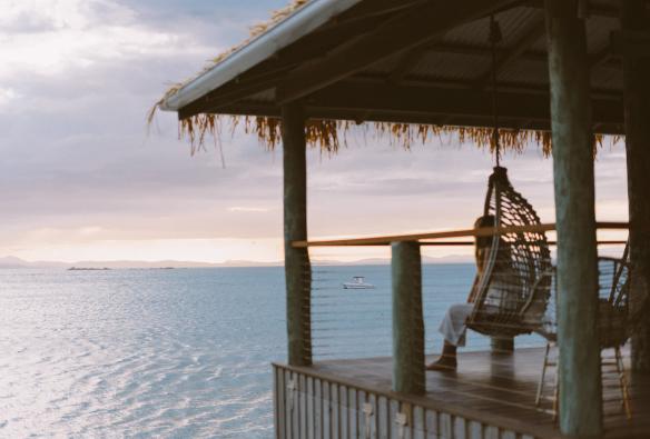 Une femme assise sur une chaise surplombant l'océan au Pumpkin Island Eco Retreat, sud de la Grande Barrière de Corail, Queensland © Pumpkin Island Eco Retreat