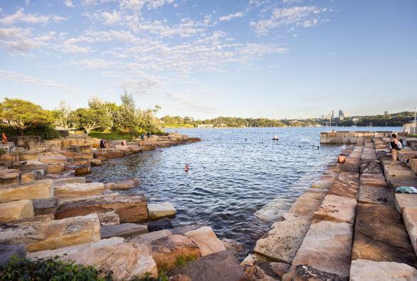 Des personnes nageant et se prélassant sur les rochers de grès entourant la piscine d'eau de mer protégée de Marrinawi Cove, Barangaroo Reserve, Sydney, Nouvelle-Galles du Sud © Images for Business